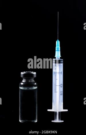 Grand flacon de vaccin complet en verre et fond noir de seringue Banque D'Images
