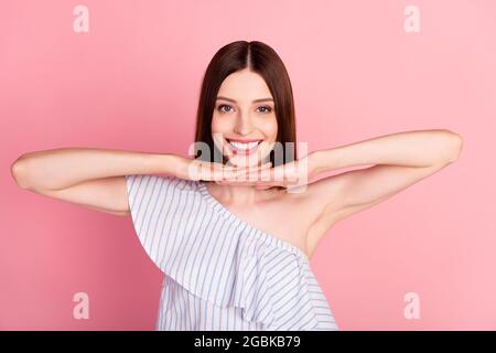 Photo de la belle brunette femme millénaire mains visage porter blouse blanche isolée sur fond de couleur rose Banque D'Images