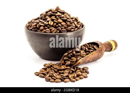 Graines de café brésiliennes grillées dans un bol en argile isolé sur fond blanc. Banque D'Images