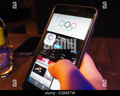 KOLKATA, INDE - 02 août 2021: Homme tenant un téléphone mobile avec des anneaux olympiques et l'application olympique sur l'écran de l'iphone Banque D'Images