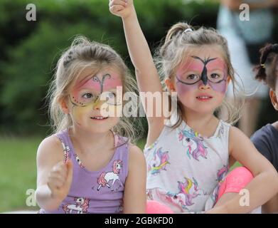 Londres, Royaume-Uni, 4 août 2021. Jumeaux identiques Lily & Scarlet Thorpe en profitant des activités du terrain de jeu East Finchley's Market place dans le nord de Londres, lors de la journée nationale de jeu annuelle du Royaume-Uni. Monica Wells/Alay Live News Banque D'Images