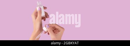 Les femmes tiennent main compte-gouttes avec du sérum sur fond de lavande pastel Banque D'Images