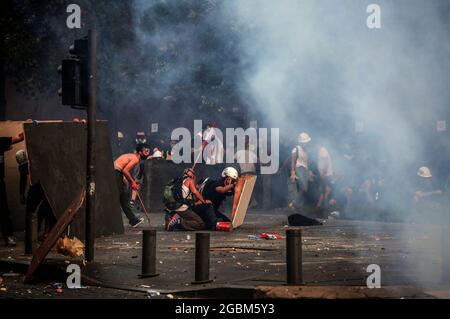 Beyrouth, Liban. 04e août 2021. Les manifestants antigouvernementaux se protègent lors d'affrontements avec la police anti-émeute et des soldats de l'armée libanaise à l'une des entrées du Parlement libanais après une marche pour marquer le 1er anniversaire de l'explosion massive du port de Beyrouth en août 2020. Le 04 août 2020, une grande quantité de nitrate d'ammonium entreposé dans le port de Beyrouth a été coupée, tuant au moins 218 personnes et en blessant 7,500 autres. Credit: Marwan Naamani/dpa/Alamy Live News Banque D'Images