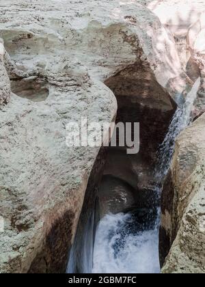 Un fragment de cascade de montagne s'écoulant entre les roches lisses de relief Banque D'Images
