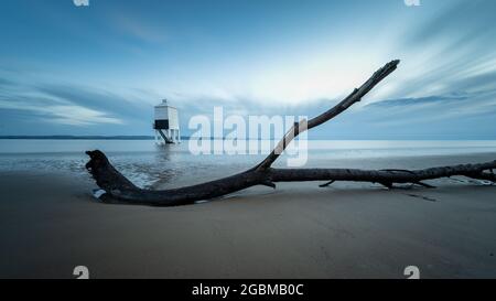 Driftwood se trouve sur la plage, près du phare de Burnham-on-Sea, dans la baie de Bridgwater, dans le Somerset. Banque D'Images