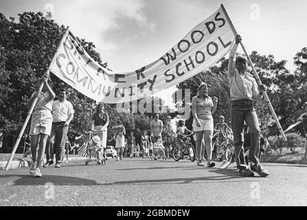 Austin Texas USA, vers 1980: Les élèves de l'école communautaire de Bryker Woods tiennent la bannière de leur école et mènent une parade d'adultes et d'enfants à pied et à vélo dans le quartier. ©Bob Daemmrich Banque D'Images