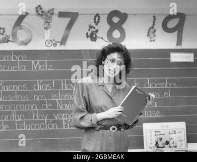 Austin Texas USA, vers 1990: Femme hispanique bilingue enseignant d'éducation travaillant avec des élèves de maternelle dans la classe publique primaire. ©Bob Daemmrich Banque D'Images