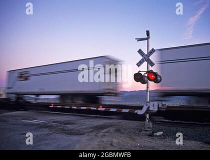 Un train de marchandises passe devant un passage à niveau à Tehachapi, en Californie Banque D'Images