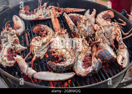 Gros plan de homards au barbecue, grillades de fruits de mer sur les coals chauds, y compris un homard Banque D'Images