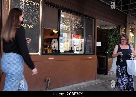 Une femme quitte l'emplacement de l'ouest de Seattle de la boulangerie Nouveau à Seattle, WA avec son achat de produits de boulangerie. Banque D'Images