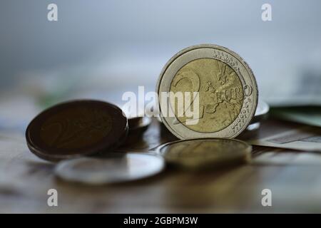 Deux pièces en euros. Pièces en euros et billets en euros sur fond vert flou. Monnaie européenne. Finances et épargne. Banque D'Images