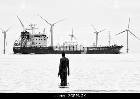 Parc éolien. Ici, nous avons divers sujets environnementaux, un parc éolien et un pétrolier avec des statues Anthony Gormley qui regardent les deux. Crosby et Liverpoo Banque D'Images