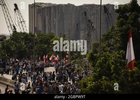 Beyrouth, Liban, le 4 août 2021. La structure désormais emblématique du silo à céréales détruit dans le Blast de Beyrouth se cache derrière les manifestants qui ne trouvent pas les responsables de l'explosion et les tiennent pour responsables un an plus tard. Banque D'Images