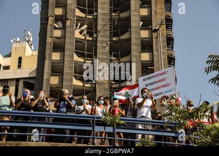 Beyrouth, Liban, le 4 août 2021. Les gens protestant contre l'incapacité de trouver les responsables du Blast de Beyrouth et des tenir pour responsables devant un bâtiment endommagé par l'explosion, encore non réparé un an plus tard. Banque D'Images