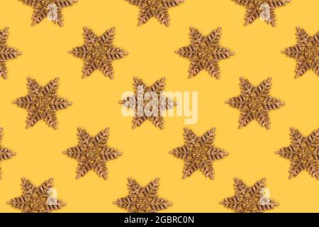 Motif flocons de neige scintillants dorés sur fond jaune. Composition de Noël. Banque D'Images