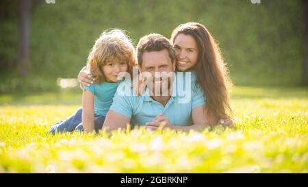 adoption et charité. journée de la famille. amitié. père mère et enfant sur l'herbe verte du parc. Banque D'Images