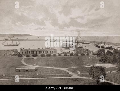 Vue de la fin du XIXe siècle sur les bateaux à aubes et les ferries dans le port de Dún Laoghaire, une ville côtière du comté de Dublin, en Irlande. Suite à la démolition de deux navires de pêche en 1807, une loi autorisant la construction de ce qui est maintenant appelé « West Pier » a été adoptée. Lorsque le roi George IV est venu visiter le nouveau port en construction en 1821, le nom de Dunleary a été abandonné en faveur de 'Kingstown'; la ville est revenue à son ancien nom en août 1920, à la suite de la création de l'État libre irlandais. Banque D'Images