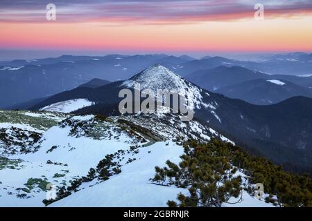 Hiver. Vue aérienne. Un lever de soleil incroyable. Hautes montagnes aux sommets enneigés. Une vue panoramique de la couverte de gelées dans les dérives. Hiver Banque D'Images