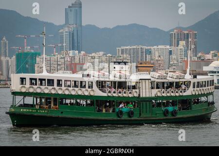 Le « Méridien Star », l'une des flottes de Star Ferry, traverse le port Victoria de Kowloon à l'embarcadère Central Ferry Pier 7 sur l'île de Hong Kong Banque D'Images