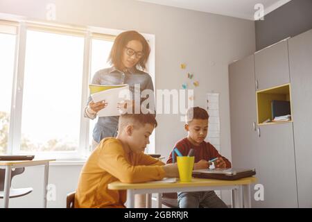 Deux garçons écrivant pendant une leçon et un test à l'école Banque D'Images