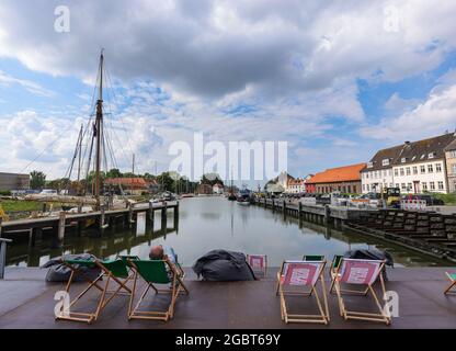 05 août 2021, Schleswig-Holstein, Glückstadt: Un passant bénéficie de la vue sur le port de Glückstadt par les températures estivales. Photo: Ulrich Perrey/dpa Banque D'Images