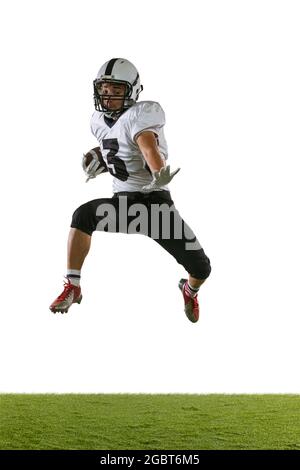 Portrait de l'entraînement américain de joueur de football isolé sur fond blanc studio avec herbe verte. Concept de sport, compétition Banque D'Images