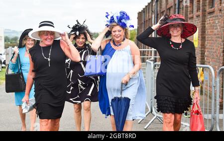 Brighton Royaume-Uni 5 août 2021 - les Racegoers s'accrochent à leurs chapeaux lorsqu'ils arrivent pour Brighton courses Ladies Day un après-midi de détente : Credit Simon Dack / Alay Live News Banque D'Images