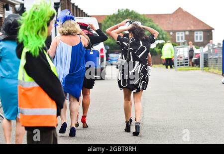 Brighton Royaume-Uni 5 août 2021 - les Racegoers s'accrochent à leurs chapeaux lorsqu'ils arrivent pour Brighton courses Ladies Day un après-midi de détente : Credit Simon Dack / Alay Live News Banque D'Images