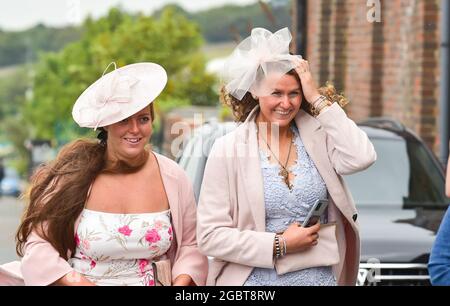 Brighton Royaume-Uni 5 août 2021 - les Racegoers s'accrochent à leurs chapeaux lorsqu'ils arrivent pour Brighton courses Ladies Day un après-midi de détente : Credit Simon Dack / Alay Live News Banque D'Images