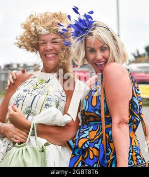 Brighton Royaume-Uni 5 août 2021 - les Racegoers s'accrochent à leurs chapeaux lorsqu'ils arrivent pour Brighton courses Ladies Day un après-midi de détente : Credit Simon Dack / Alay Live News Banque D'Images
