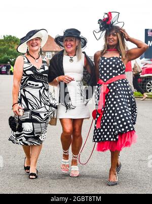Brighton Royaume-Uni 5 août 2021 - les Racegoers s'accrochent à leurs chapeaux lorsqu'ils arrivent pour Brighton courses Ladies Day un après-midi de détente : Credit Simon Dack / Alay Live News Banque D'Images
