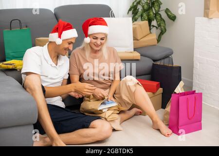 Portrait d'un couple regardant l'album photo à noël Banque D'Images