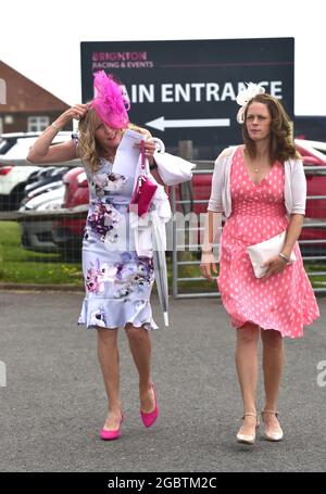 Brighton Royaume-Uni 5 août 2021 - les Racegoers s'accrochent à leurs chapeaux lorsqu'ils arrivent pour Brighton courses Ladies Day un après-midi de détente : Credit Simon Dack / Alay Live News Banque D'Images