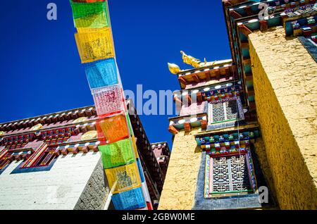 Drapeaux de prière tibétains colorés qui diffusent de la chance et des bénédictions accrochées au mur du monastère. Banque D'Images