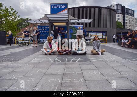 Londres, Royaume-Uni. 5 août 2021. Les manifestants s'assoient devant un poste d'information HS2. Des militants se sont rassemblés devant la gare de King's Cross pour protester contre le nouveau système ferroviaire High Speed 2 (HS2), qui selon les écologistes sera « écologiquement dévastateur » et coûtera aux contribuables 170 milliards de livres sterling. (Crédit : Vuk Valcic / Alamy Live News) Banque D'Images