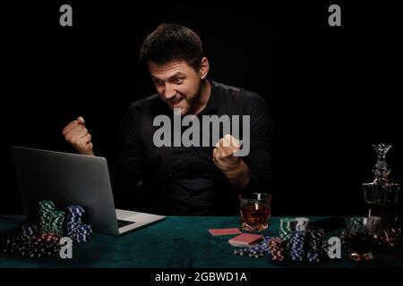 Joueur de casino barbu en ligne homme célébrant la victoire Banque D'Images