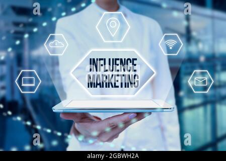 Texte d'écriture influencer le marketing. Le mot écrit sur l'utilisation des leaders clés pour conduire une marque est le message à la dame du marché dans la tenue uniforme tablette en main Banque D'Images