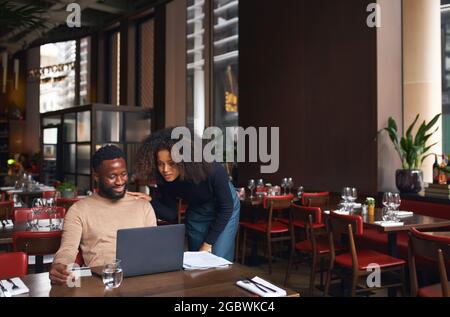 Propriétaires de petites entreprises utilisant un ordinateur portable dans le restaurant Banque D'Images