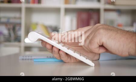 Homme d'affaires travaillant avec des factures, effectue des calculs financiers avec Adding machine. Calcul des frais comptables et des taxes. Banque D'Images