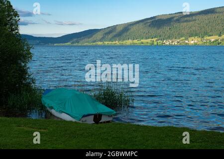 Un bateau à moteur situé sur les rives du lac de Joux, en Suisse, en plein soleil l'après-midi Banque D'Images