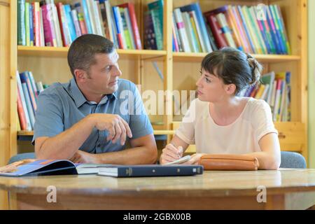 l'homme et la femme de la bibliothèque se sont concentrés sur l'apprentissage Banque D'Images