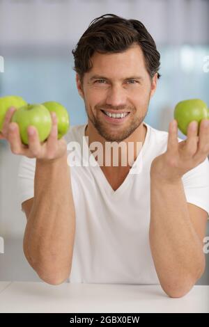 jeune homme tenant des pommes vertes Banque D'Images