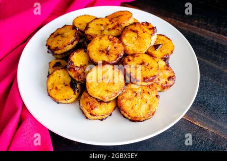 Bananes plantains cuites au caramel et à la cannelle : une assiette de plantains cuits à la cannelle et au sucre caramélisé Banque D'Images