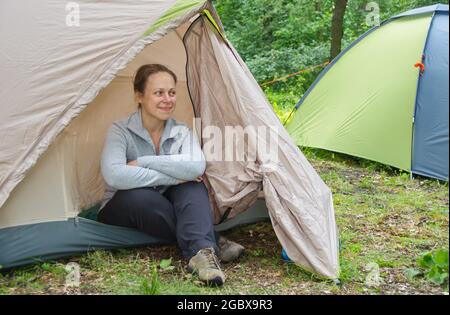 Dnepropetrovsk, Ukraine - 05.30.2015: Une jeune femme s'assoit à côté d'une tente et admire la nature au milieu de la forêt. Le concept de l'extérieur Banque D'Images