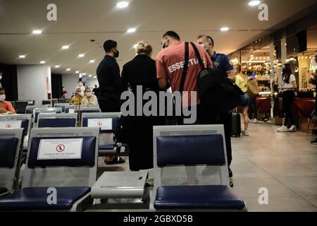 Un policier calme les passagers qui se disputent des mesures contre le coronavirus (COVID-19) à l'aéroport Milas-Bodrum de Mugla, Turquie, le jeudi 5 août 2021. (Photo par Ilker Eray/GochreImagery/Sipa USA) Banque D'Images