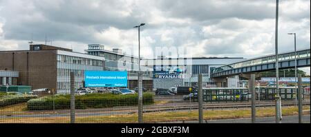 Extérieur de l'aéroport international de Prestwick / aéroport de Glasgow Prestwick avec panneau. Passerelle de la gare sur la droite de la photo. Banque D'Images