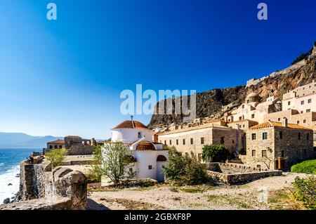 Vue sur la rue Monemvasia avec panorama avec les vieilles maisons et l'église Panagia Chrysafitissa dans la ville ancienne, Péloponnèse, Grèce Banque D'Images