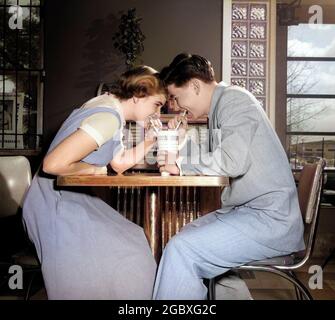 ANNÉES 1950, LES DEUX GARÇONS ET FILLES QUI SE MOQUE D'UN COUPLE ADOLESCENT PARTAGENT UNE BOISSON AVEC DEUX PAILLES DANS UN SODA-SHOP - F6771C HAR001 HARS ROMANCE DINER SODA FONTAINE COULEUR PARTAGE PAILLE RAPIDE RELATION JONQUE LIQUIDE VIEUX TEMPS NOSTALGIE VIEILLE MODE JEUNE BLOC RIRE EN-CAS STYLE DE VIE GROGNUP COPIE ESPACE DEMI-LONGUEUR ADULTE ADOLESCENTE ADOLESCENTE ADOLESCENT GARÇON NOURRITURES HOMMES ET FEMMES JUKE POP JUKE RÊVES JUKE JUKE JUKE JUKE JUKE JUKE RESTAURATION RAPIDE BOISSON NOURRISSANT COMPAGNON AMOROUS SNACK NOURRITURE AUTOMATIQUE ET FLUIDE 45 HOMME ET FEMME RECORD JOUEUR DÉJEUNER STAND 45 RPM ATTRACTION AIMER LA BOISSON DOUCE D'AUDIENCE SÉLECTION MUSICALE RIRE AFFECTUEUX NOURRITURE Banque D'Images