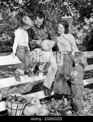 FAMILLE DE QUATRE ENFANTS DES ANNÉES 50 EN AUTOMNE MÈRE FILLE DEBOUT PAR SON FILS ASSIS SUR UNE CLÔTURE BLANCHE REGARDANT LE PÈRE SCULPTER LA CITROUILLE D'HALLOWEEN - H819 HAR001 HARS CLÔTURE QUATRE AUTOMNE MOM CITROUILLE NOSTALGIQUE AUTOMNE PAIRE 4 SUBURBAINES MÈRES MAGIC VIEUX TEMPS OCCUPÉ NOSTALGIE VIEILLE MODE 1 JUVÉNILE ÉQUILIBRE TRAVAIL D'ÉQUIPE SCULPTANT LES FILS FAMILLES JOIE VIE CÉLÉBRATION FEMMES MARIÉE RURAL CONJOINT ÉPOUX MAISON VIE COPIE ESPACE PLEINE LONGUEUR FEMMES FILLES PERSONNES INSPIRATION HOMMES BIENVEILLANT CONFIANCE PÈRES B&W PARTENAIRE BUTS BONHEUR LOISIR FORCE DADS EXCITATION RÉCRÉATION FIERTÉ PAR DANS DE SUR LA CONNEXION D'AUTORITÉ CONCEPTUELLE Banque D'Images