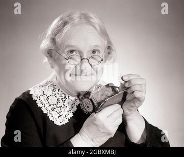 50ANS FRUGAL PENNY PINCHING GRANDMA CHEVEUX GRIS COLLIER EN DENTELLE REGARDANT LA CAMÉRA METTRE PIÈCE DANS LE SAC À MAIN DE CHANGEMENT - S7829 DEB001 HARS B&W SENIOR FEMME ÂGE OLDSTERS OLDSTER PERSONNAGES FRUGAL GRAND-MÈRES CHEVEUX BLANCS ANCIENS DEB001 MISLY BIDDY VIEILLE FEMME GRIS NOIR ET BLANC CAUCASIEN GRANDMA OLD FASHION Banque D'Images